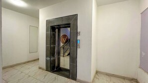 A hallway with a mirrored door leading to a staircase. - Nairobi Jkia Retreat With Pool Wifi and 24hrs Gym (Syokimau)