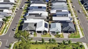 Un quartier résidentiel comprenant des maisons, une rue et un espace vert avec une aire de jeux.
