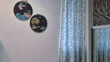 A wall with two circular wall art pieces and a patterned curtain.