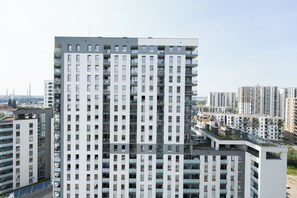 Un immeuble résidentiel de grande hauteur, doté de nombreux balcons, d’une façade plane et offrant une vue dégagée sur l’environnement urbain.