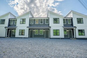 A two-story house with a gravel driveway and multiple windows. - Spacious 4-bedroom townhome in enchanting downtown Bryson City (Bryson City)