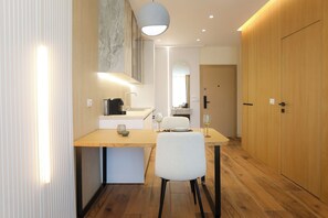 A modern kitchen with a wooden countertop, a sink, and a dining area with a chair and table. - Modern Pool Side Studio Palm, Vlore, Albania (Vlore)