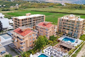 A multi-story hotel with a rooftop pool and outdoor seating area.