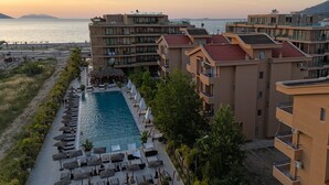 Ein Resort mit Pool, Liegestühlen und Meerblick.