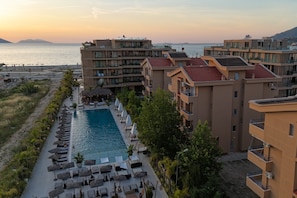 Ein Resort mit Pool, Liegestühlen und Meerblick.