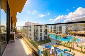 Ein Balkon mit Blick auf einen Swimmingpool und angrenzende Gebäude.