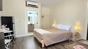 Een slaapkamer met een bed, nachtkastjes, een bureau en een stoel.