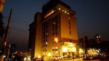Een meerhoog gebouw met grote ramen en een bord dat een hotel aangeeft.