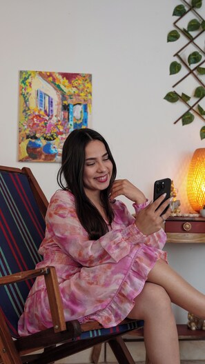 A person sitting on a chair with a colorful painting in the background.