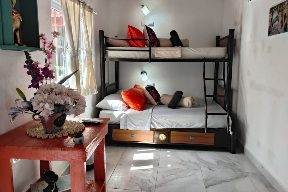 A bunk bed room with a table, a lamp, and a statue.
