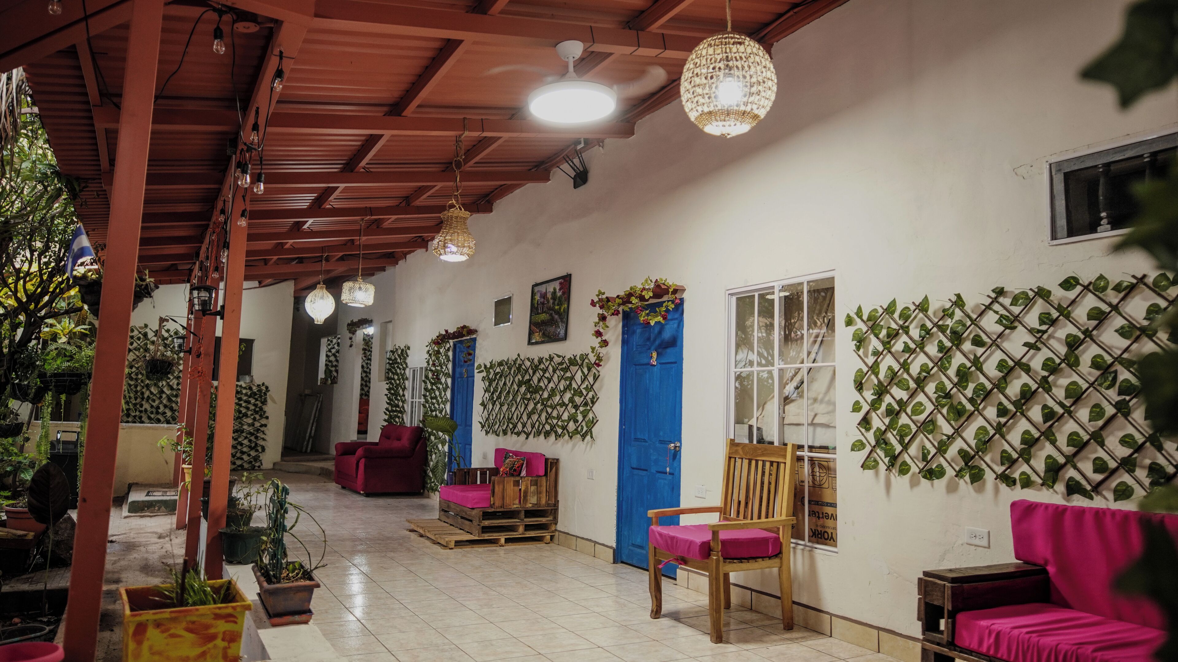 A room with a wooden ceiling, a blue door, and a wall-mounted plant grid.