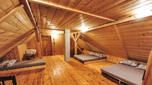 A wooden attic room with two beds, a table, and a bench. - U Kazíků by Interhome (Vysoké nad Jizerou)