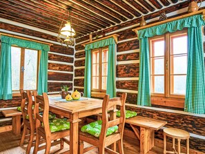 A rustic wooden cabin interior with a wooden dining table, chairs, and benches. - U Kazíků by Interhome (Vysoké nad Jizerou)