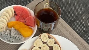 A breakfast plate with toast, eggs, and a side salad, accompanied by a bowl of fruit and a cup of tea. - La Petite Maison Luang Prabang (Luang Prabang)