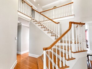 A multi-level staircase with white railings and wooden handrails.