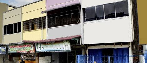 A multi-story building with a ground-level shop and a blue gate.