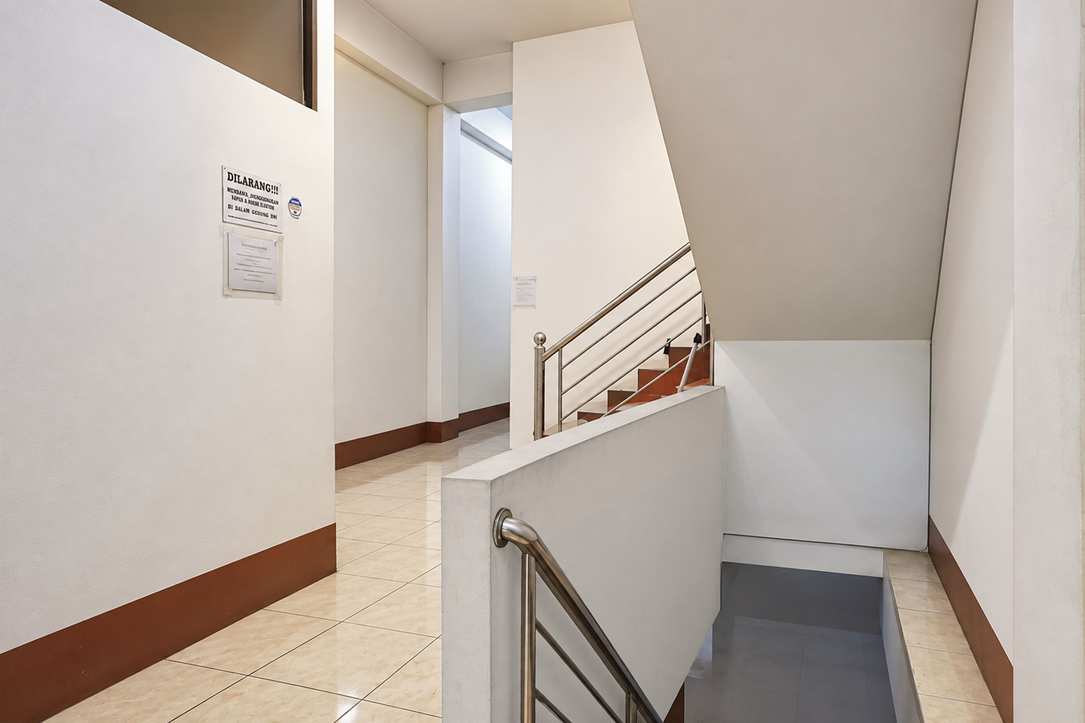 Interior moderno com escada, um aviso na parede e piso de azulejos.