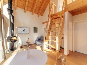 A modern interior with a wooden ceiling, a fireplace, a ladder, and a sofa. - Chalet Nr. 6 für 2 Personen mit Sauna by Interhome (Niederwölz)