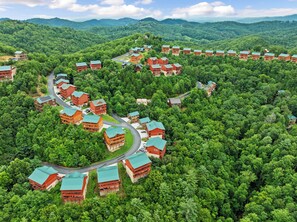 A resort with multiple buildings surrounded by dense forest, featuring a winding road connecting the structures. - The Ridgeline Reserve • Luxe Lodge w/ Private Indoor Pool • Top 5% (Sevierville)