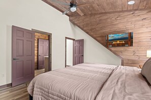 A bedroom with a sloped ceiling, a bed, and a painting of a fireplace. - The Ridgeline Reserve • Luxe Lodge w/ Private Indoor Pool • Top 5% (Sevierville)