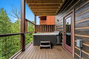 A wooden deck with a hot tub, a small table, and a bench. - The Ridgeline Reserve • Luxe Lodge w/ Private Indoor Pool • Top 5% (Sevierville)