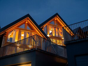 Ein zweistöckiges Holzhaus mit Balkonen und großen Fenstern, vermutlich ein Hotel oder eine Pension.
