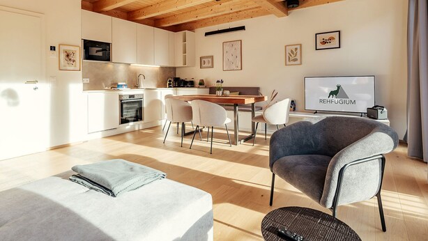 Un intérieur moderne comprenant une cuisine, un coin repas et un espace de vie.