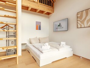 Ein Schlafzimmer mit einem Bett, einer Holzhockerregal, einem gerahmten Bild und einer Wanddekoration.