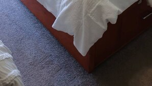 A hotel room with a bed, a desk, and a chair.