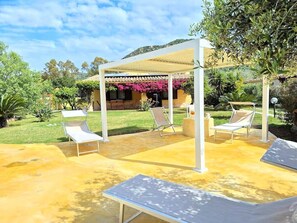 An outdoor patio with lounge chairs and a pergola structure. - Villa Carlebia - Private pool and garden. Beaches within walking distance, ideal for families (Sinnai)