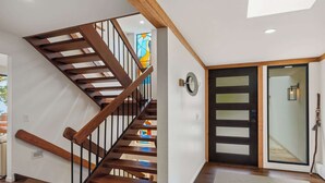 Eine Holztreppe mit einer Glastür zu einem Zimmer.
