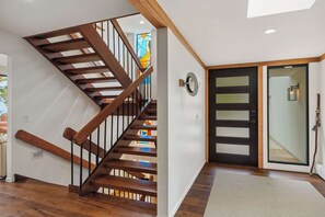 A wooden staircase with a glass door leading to a room. - Tide n Timber 4BR 2.5 BA (Pebble Beach)
