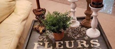 A table with a plaque reading 'FLEURS ETABLISSEMENT 1907 PARIS' and a potted plant on it.