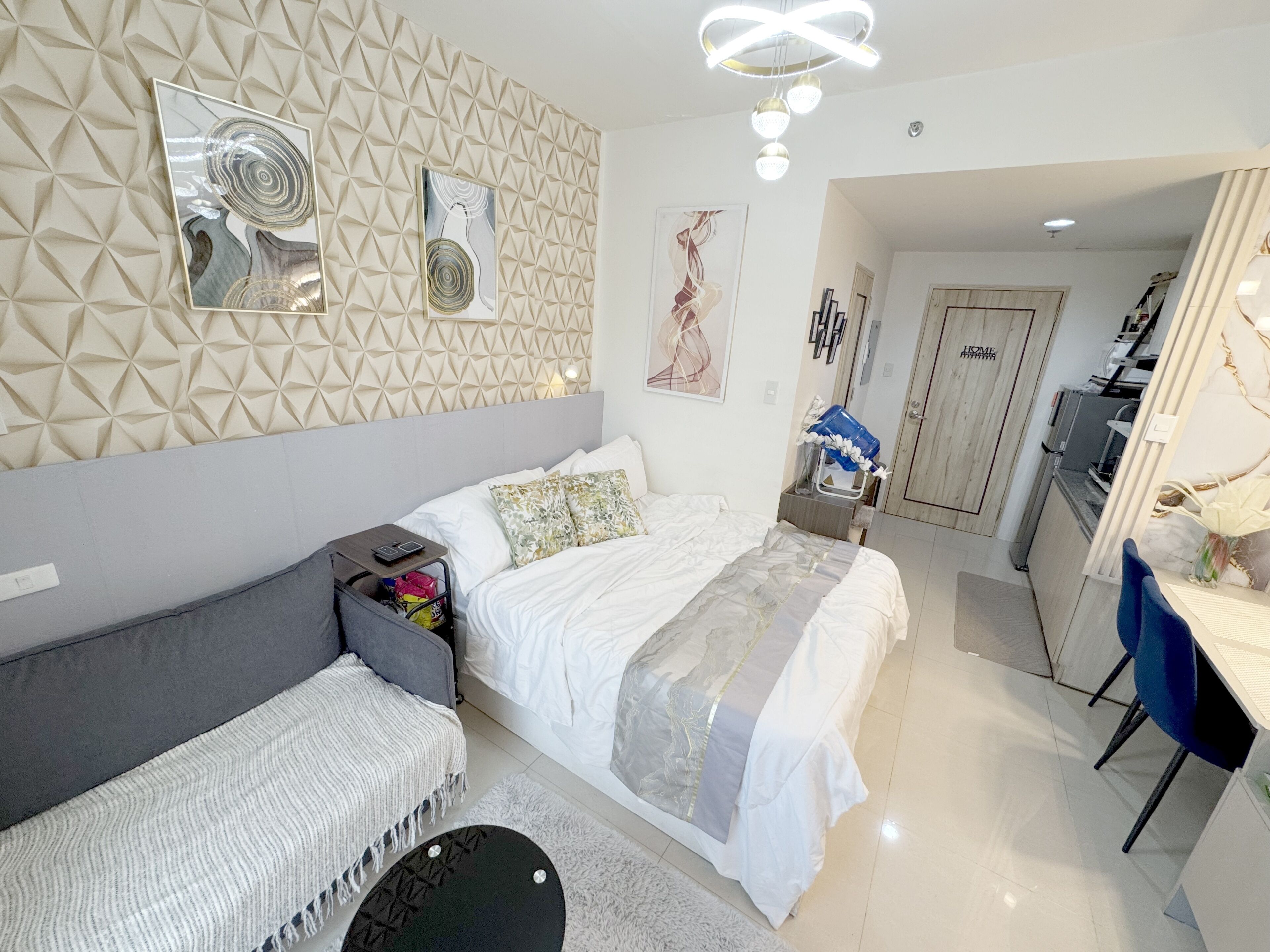 A modern bedroom with a bed, bedside table, and a desk area.