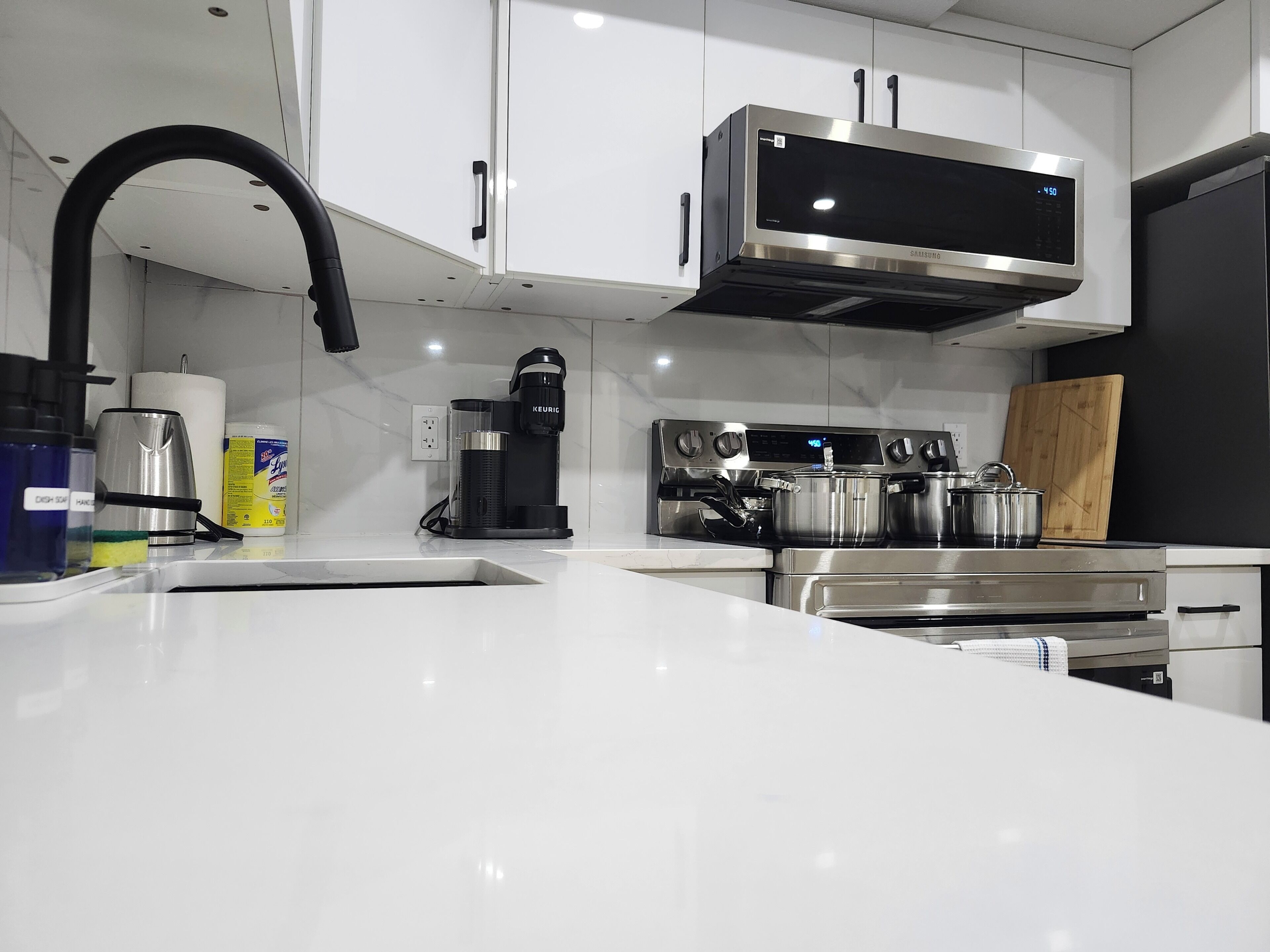 A modern kitchen with stainless steel appliances, a coffee maker, and a microwave.
