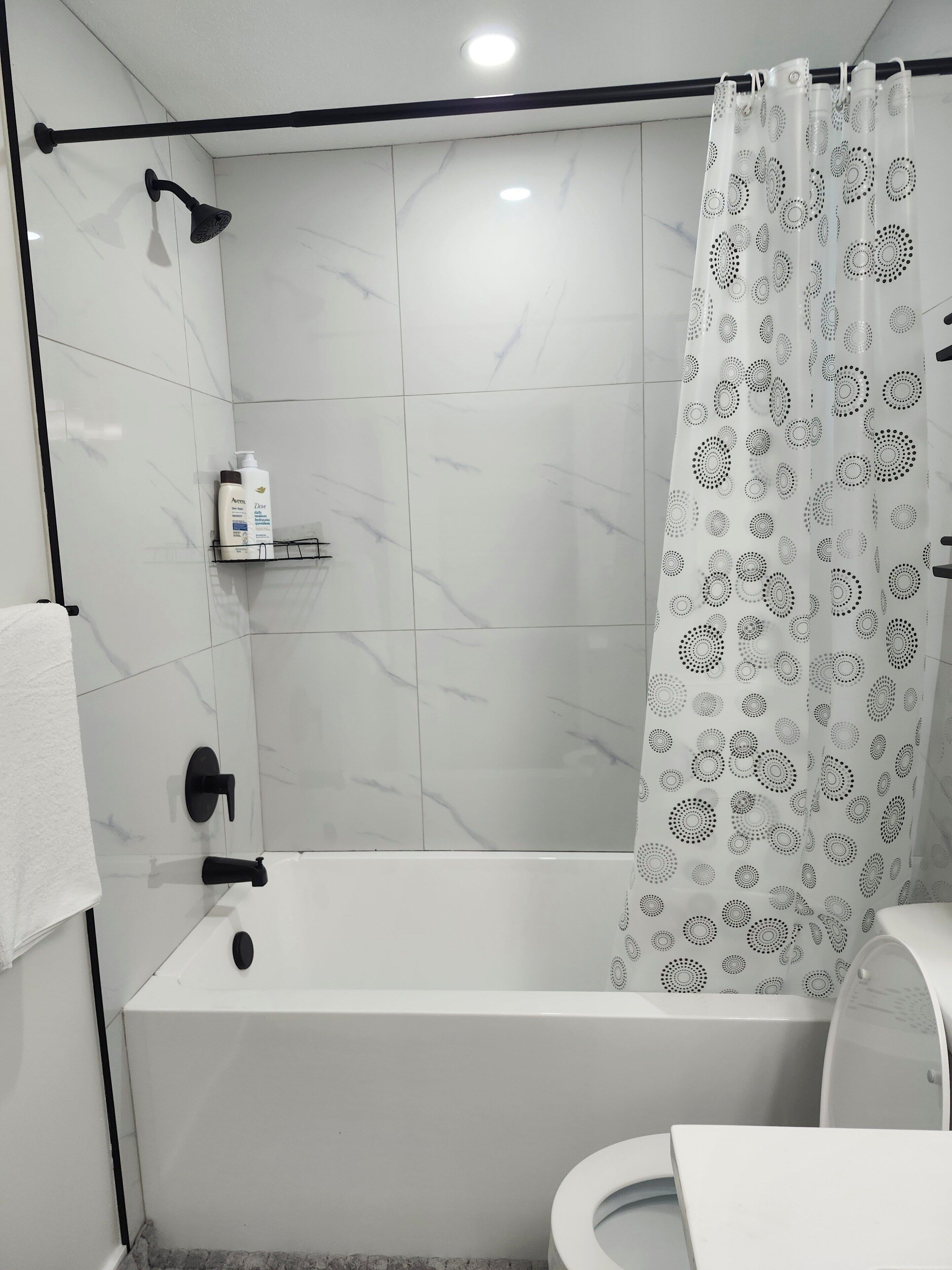 Ein modernes Badezimmer mit Badewanne, Dusche und Toilette.