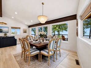 A dining area with a round table, chairs, and a chandelier.