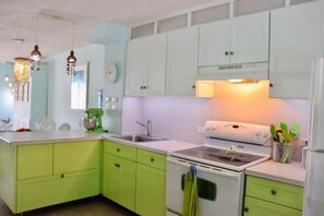 A kitchen with green cabinets, a white stove, and a sink. - La Dolce Villa in Jolly Harbour Antigua (Jolly Harbour)