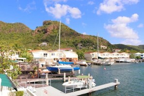 A marina with boats docked, a dock, and houses in the background. - La Dolce Villa in Jolly Harbour Antigua (Jolly Harbour)