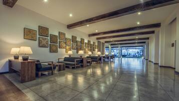 A spacious lobby with a long reception desk, multiple seating areas, and a view of the outdoors.