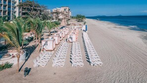 A beachside hotel with rows of sun loungers and palm trees. - The Skyloft Oceanfront (Punta Chame)