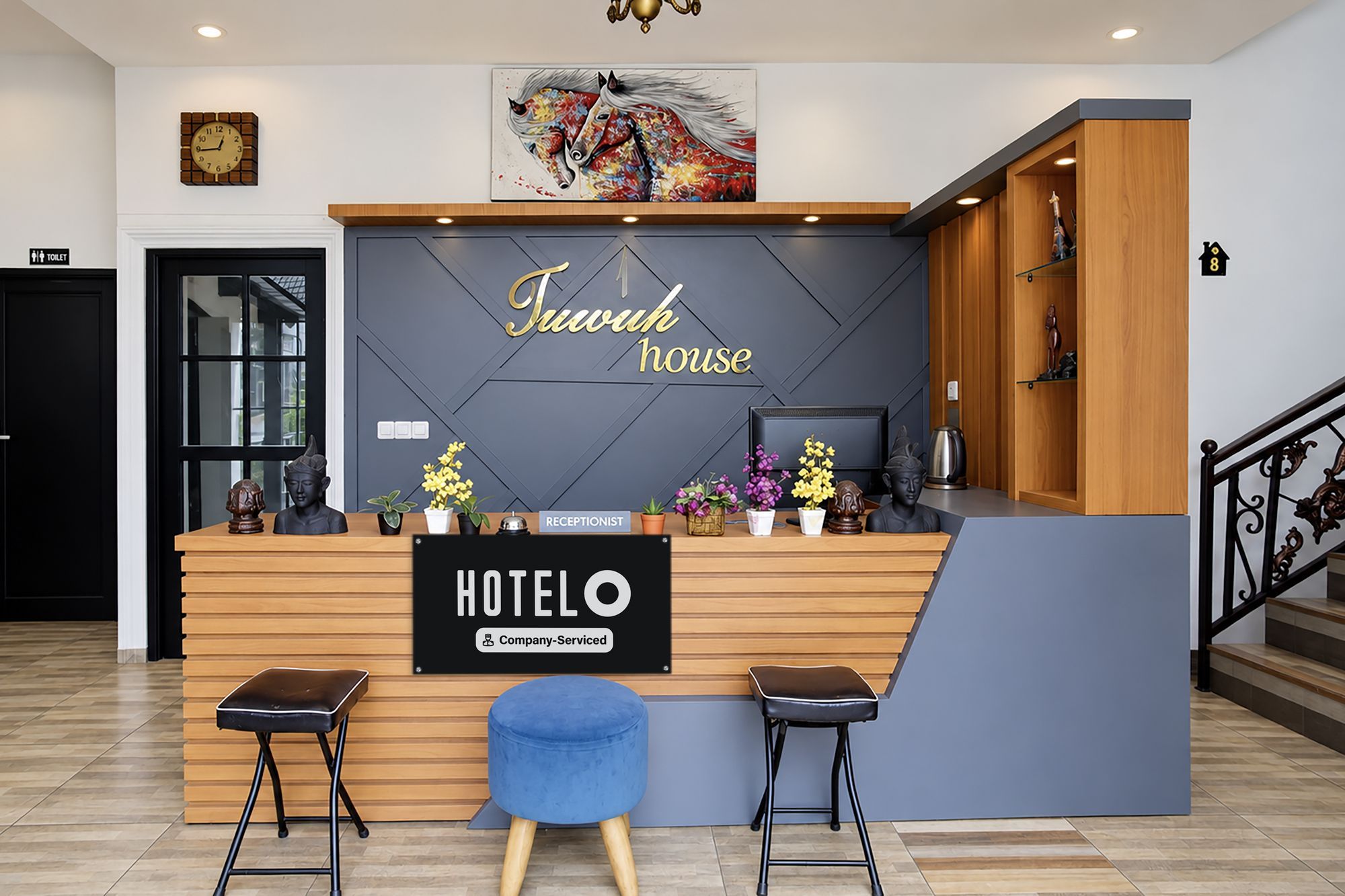 A hotel reception desk with a sign reading 'Hotel House' and a 'Hotel' sign below it. There are two bar stools, a receptionist sign, and a 'Company-Served' label.