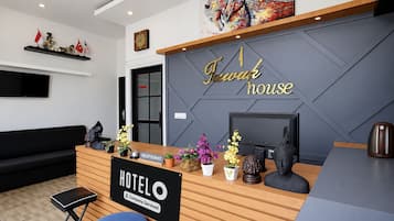 Un mostrador de recepción de hotel con un letrero que dice 'Hotel House' y un letrero de 'Hotel' debajo.