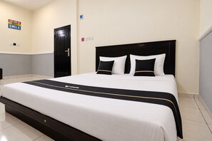 A neatly made bed with a black and white headboard, a black and white bedspread, and a sign on the wall that says 'START EVERY DAY WITH A SMILE'. - Hotel O near Mall Boemi Kedaton 1 (Bandar Lampung)