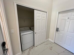A laundry room with a washing machine and dryer, a door with a lock, and a tiled floor. - 2BR/2BA Westgate Villa Near Disney Resort Pools & Family Fun (Kissimmee)