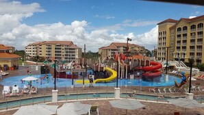 Ein Wasserpark mit Rutschen und Pools, umgeben von Gebäuden mit Balkonen.