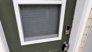 A green door with a window above it, a keypad lock, and a welcome mat. - Mt. Fisher Legal Guest Suite –Private Entrance. (Cranbrook)