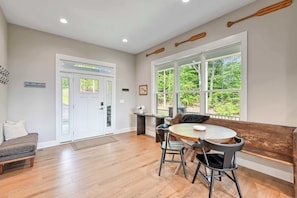 A modern interior with a dining area, a bench, and a view of the outdoors. - New Family Retreat-Sleeps24-Theatre-Dock-HotTub (Mineral)
