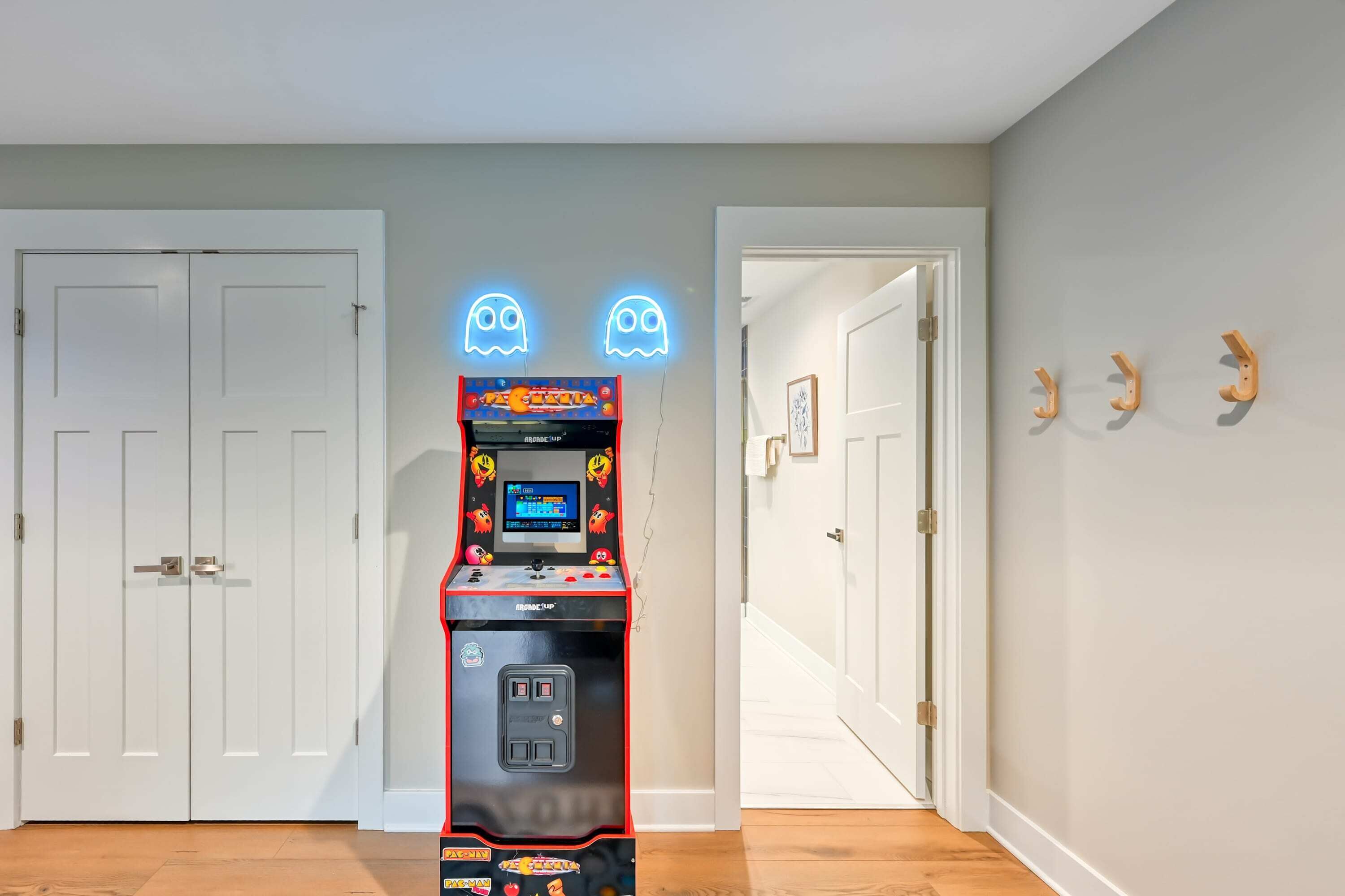 Et værelse med en Pac-Man arkademaskine, to hvide døre og en gang.