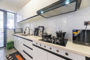 A modern kitchen with a gas stove, a coffee maker, and a range hood. - Cozy 2 BR with Heater,Gym,Pool,ample parking on 3floors at Lavington,Nairobi (Nairobi)